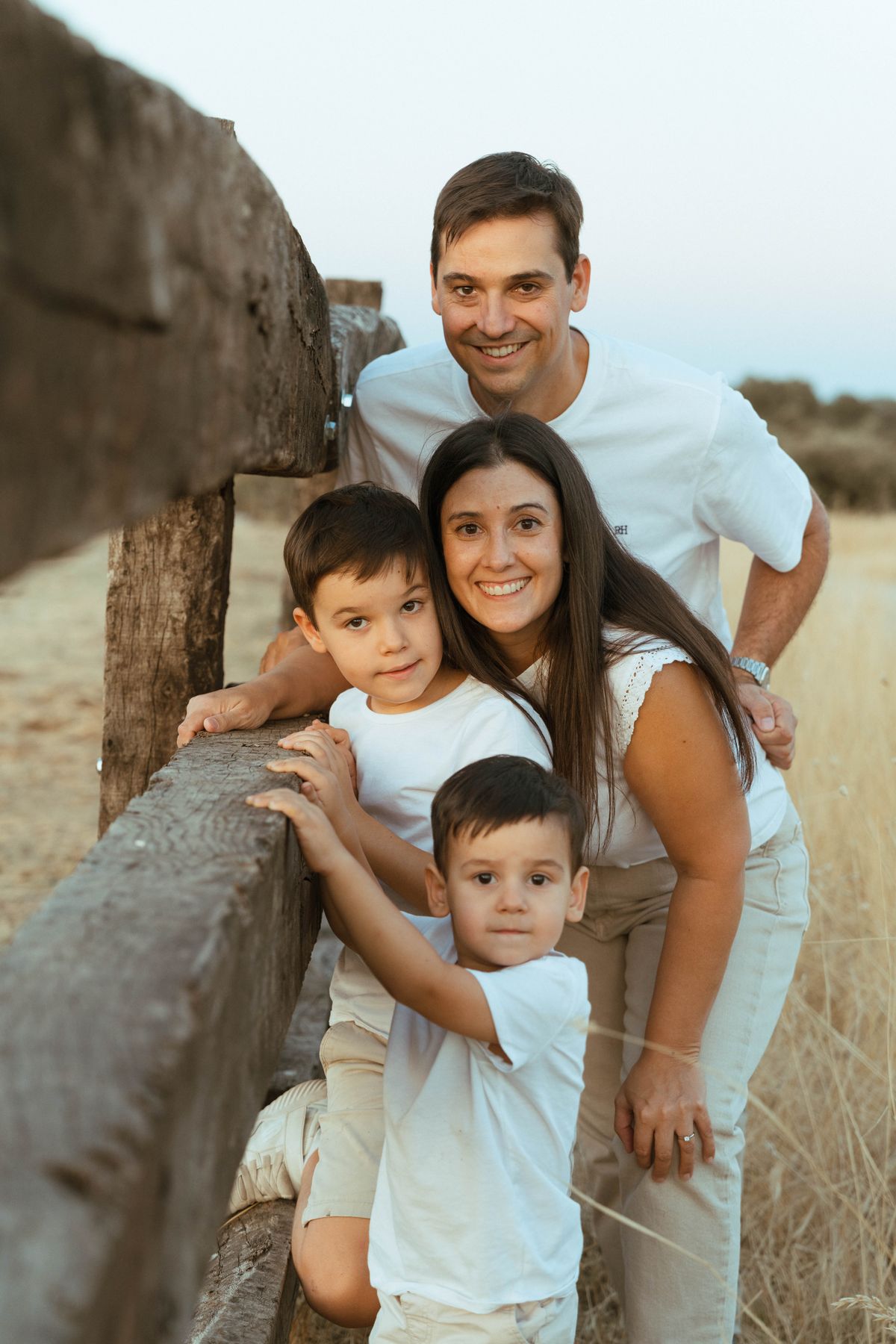 La familia apoyada en una valla de madera